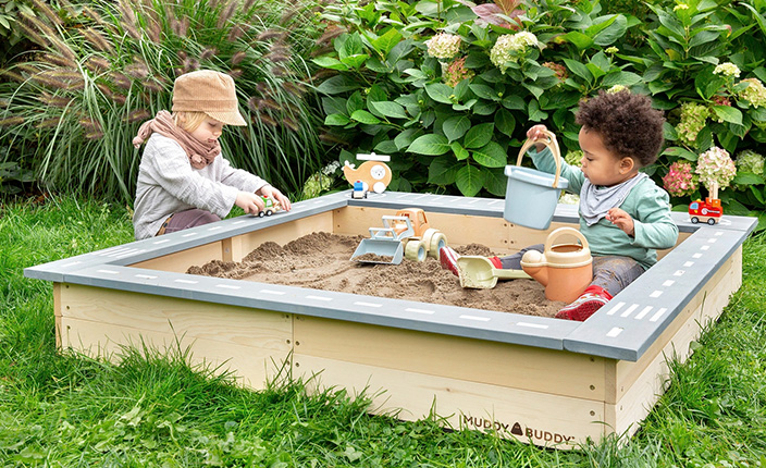 Zwei Kinder spielen in einem Sandkasten