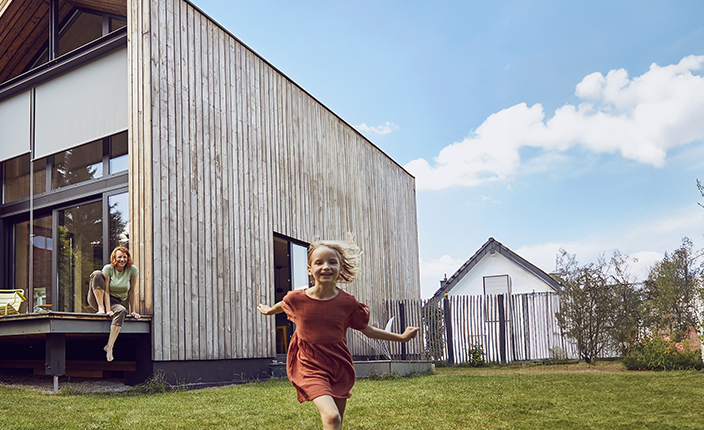 Ein Kind läuft vor einem Tiny House