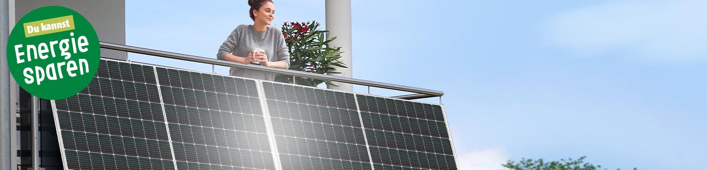 Frau steht auf Balkon mit Balkonkraftwerk