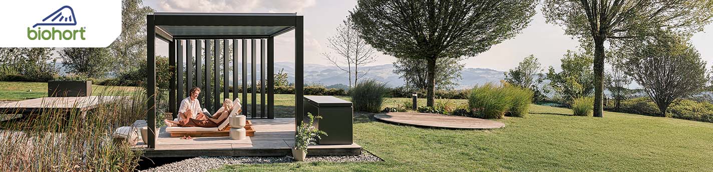 Ein Pergola steht in einem Garten mit zwei Personen im Bild