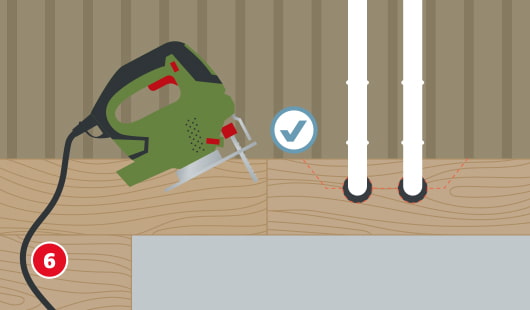 Illustration zum sechsten Schritt beim Verlegen von Vinylboden. Zwei weiße Rohrleitungen ragen durch bereits verlegte Bodenpaneele. Eine Stichsäge liegt links bereit, rote gestrichelte Linien zeigen die sauberen Rundschnitte in der Paneele.