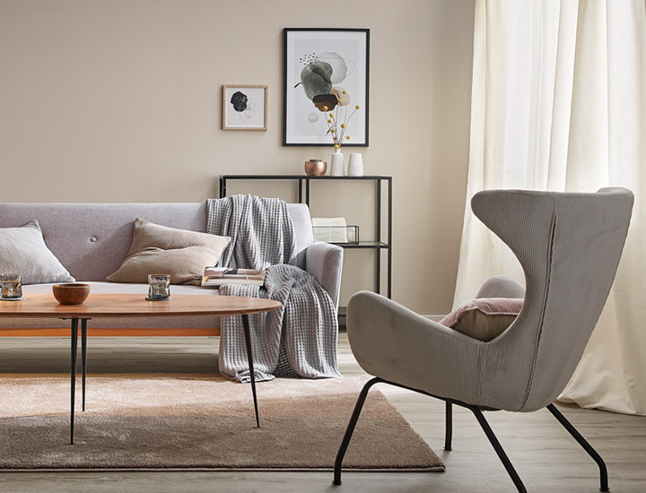 Eingerichtetes Wohnzimmer mit grauen Sitzmöbeln und dekorierten Wänden