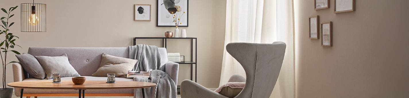 Eingerichtetes Wohnzimmer mit grauen Sitzmöbeln und dekorierten Wänden